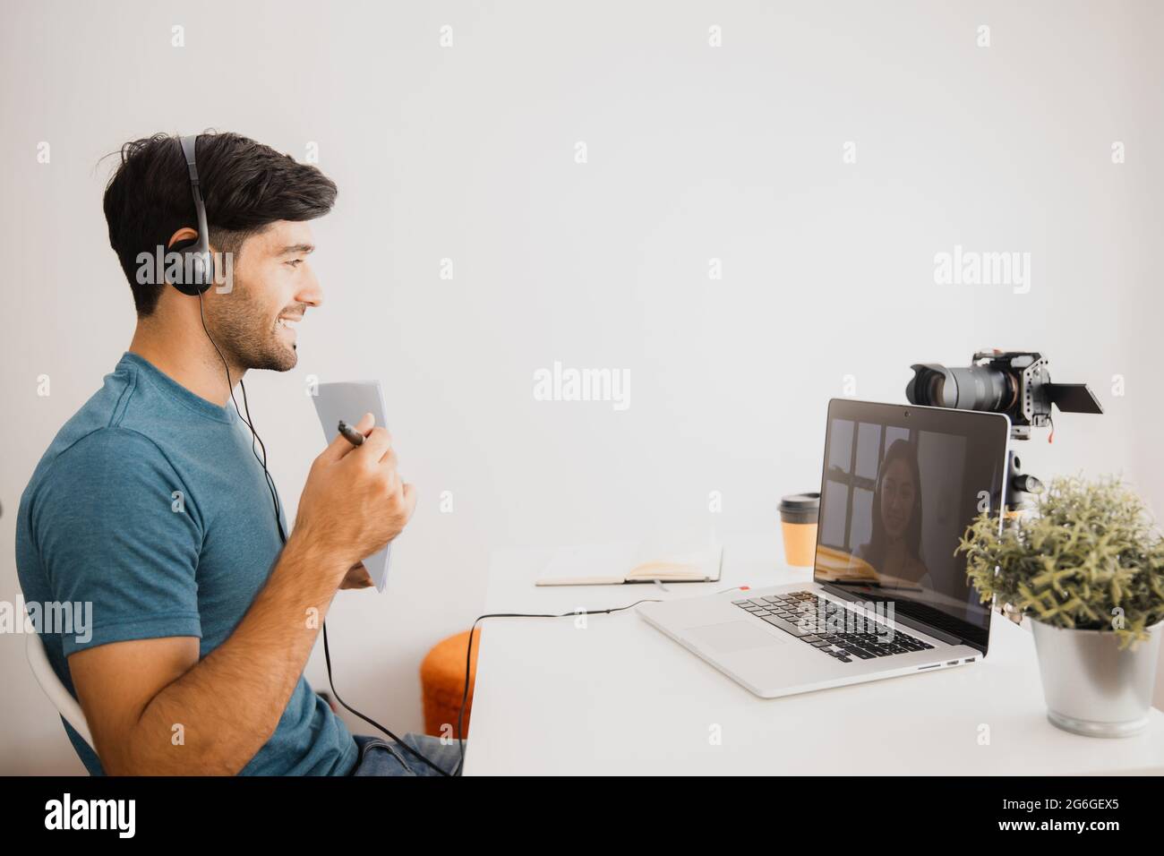 Teacher man holding paper and teach online and look at laptop to chat with student in front of camera during quarantine and work from home Stock Photo