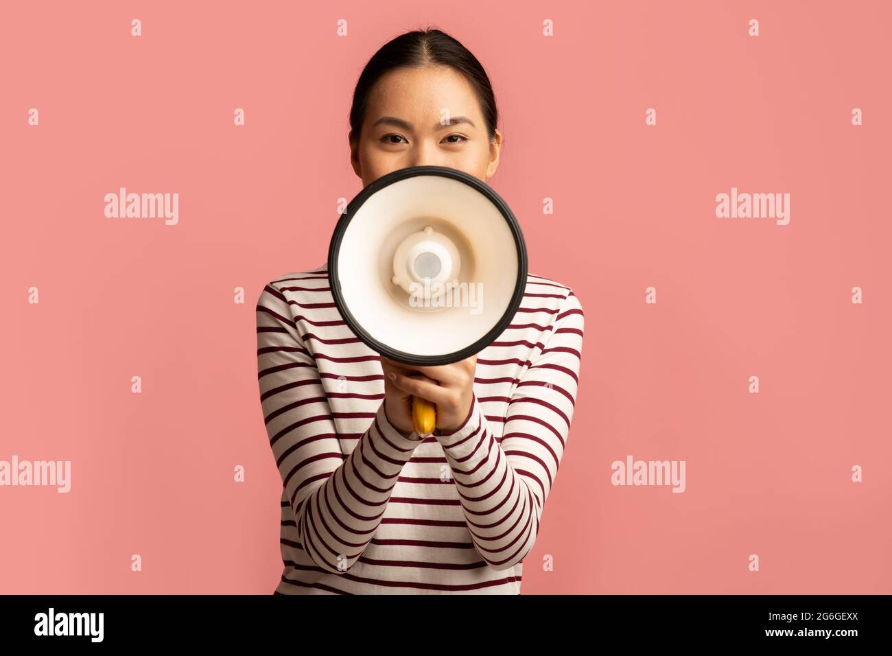 Portrait Of Young Asian Woman With Megaphone In Hands Making Announcement Stock Photo