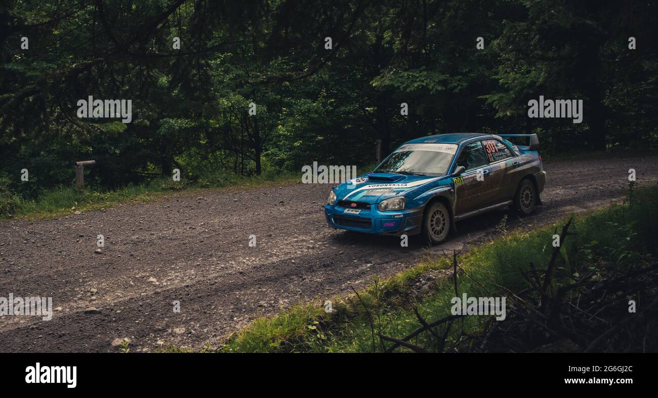 Action shot of rally car during a competition on muddy forst tracks ...