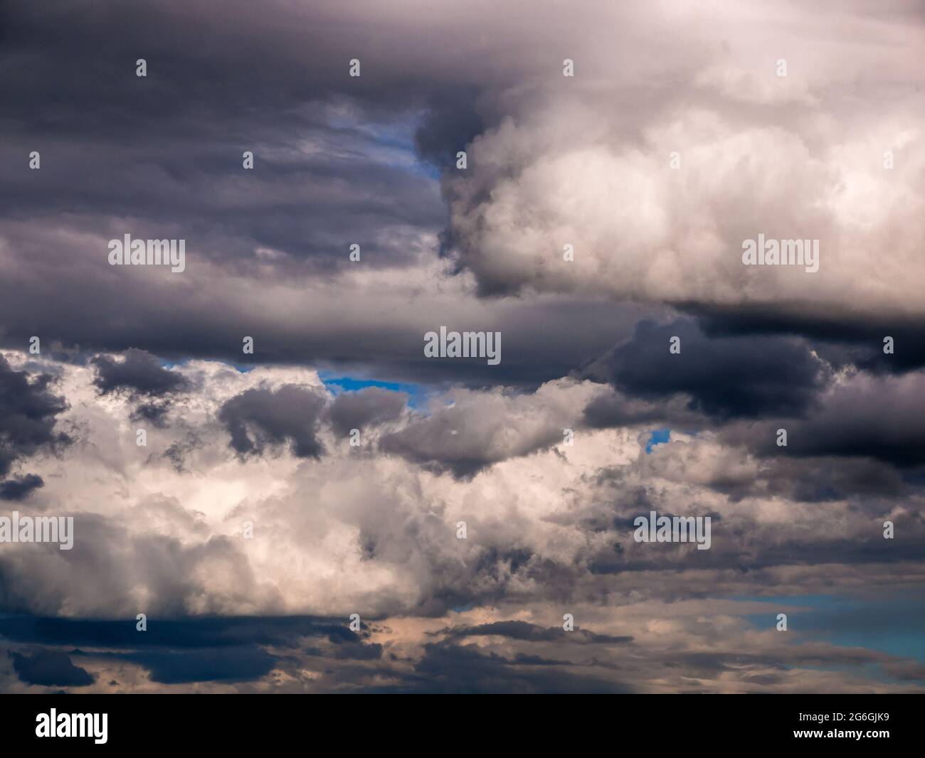 Dramatic heavy and dark rain clouds partially torn by the wind Stock Photo