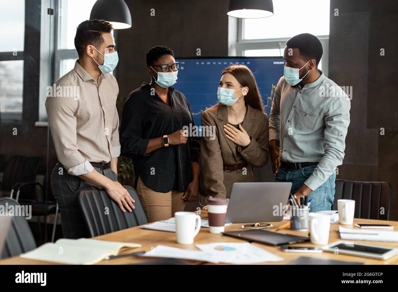 Colleagues in masks having meeting in boardroom, talking Stock Photo