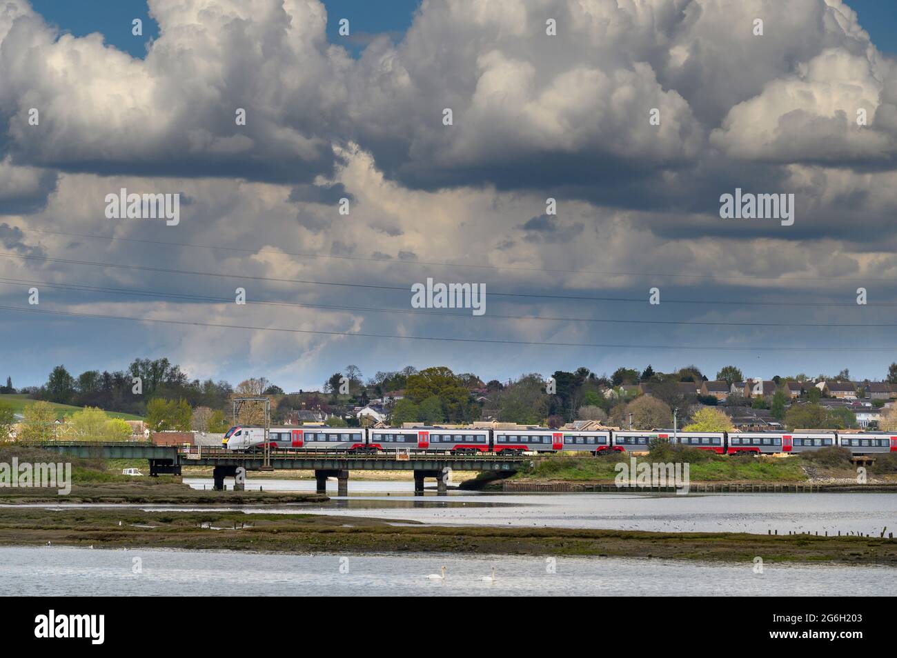 Class 745 passenger train in Greater Anglia livery crossing the Manningtree Viaduct, across the River Stour, Essex, England. Stock Photo
