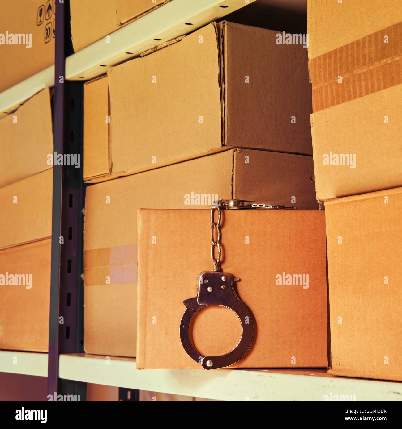 Handcuffs for arresting a criminal in a warehouse among cardboard boxes