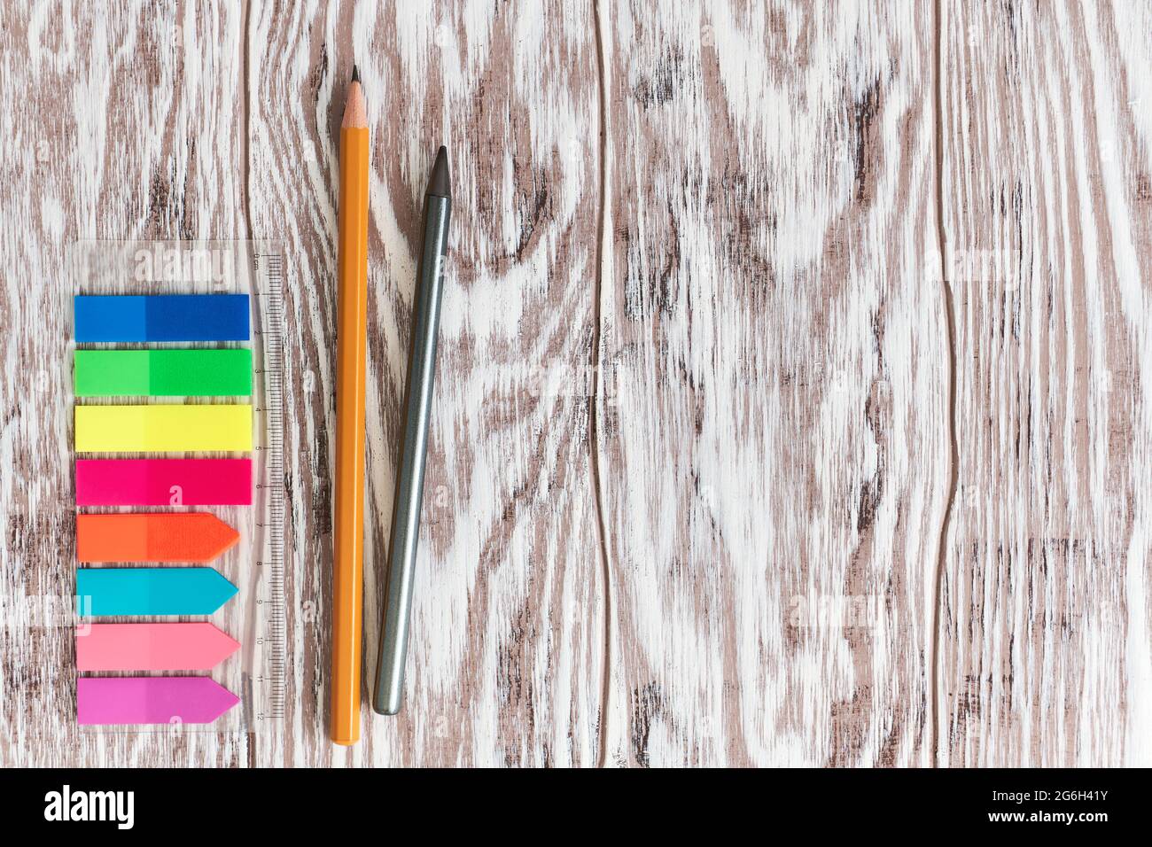 Colorful self-adhesive labels on the ruler and close-up pencils on a wooden  table with copy space Stock Photo - Alamy