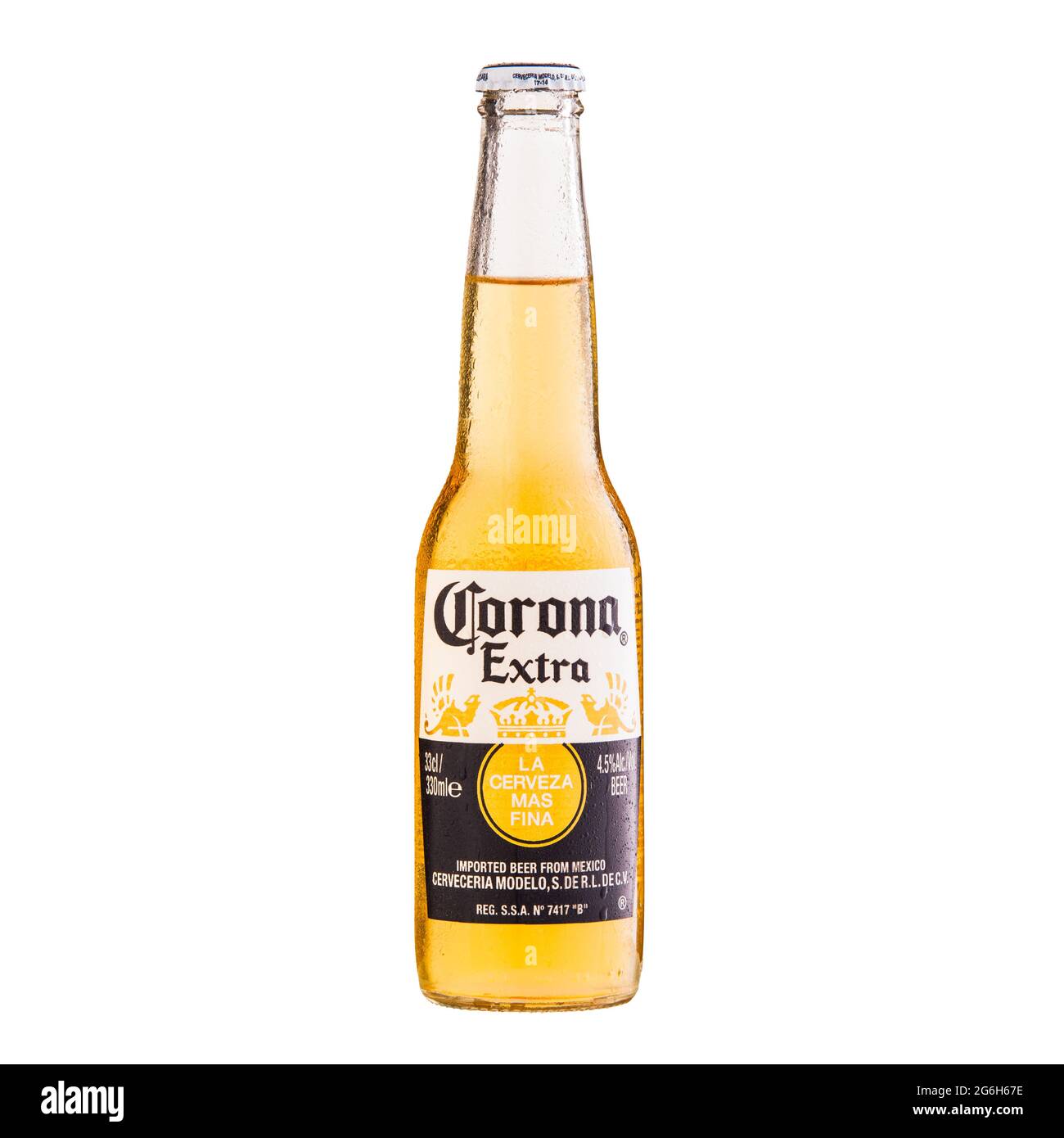 Corona Extra Beer bottle stands on glass table isolated on white - Volgograd, Russia - June 03, 2021. Stock Photo