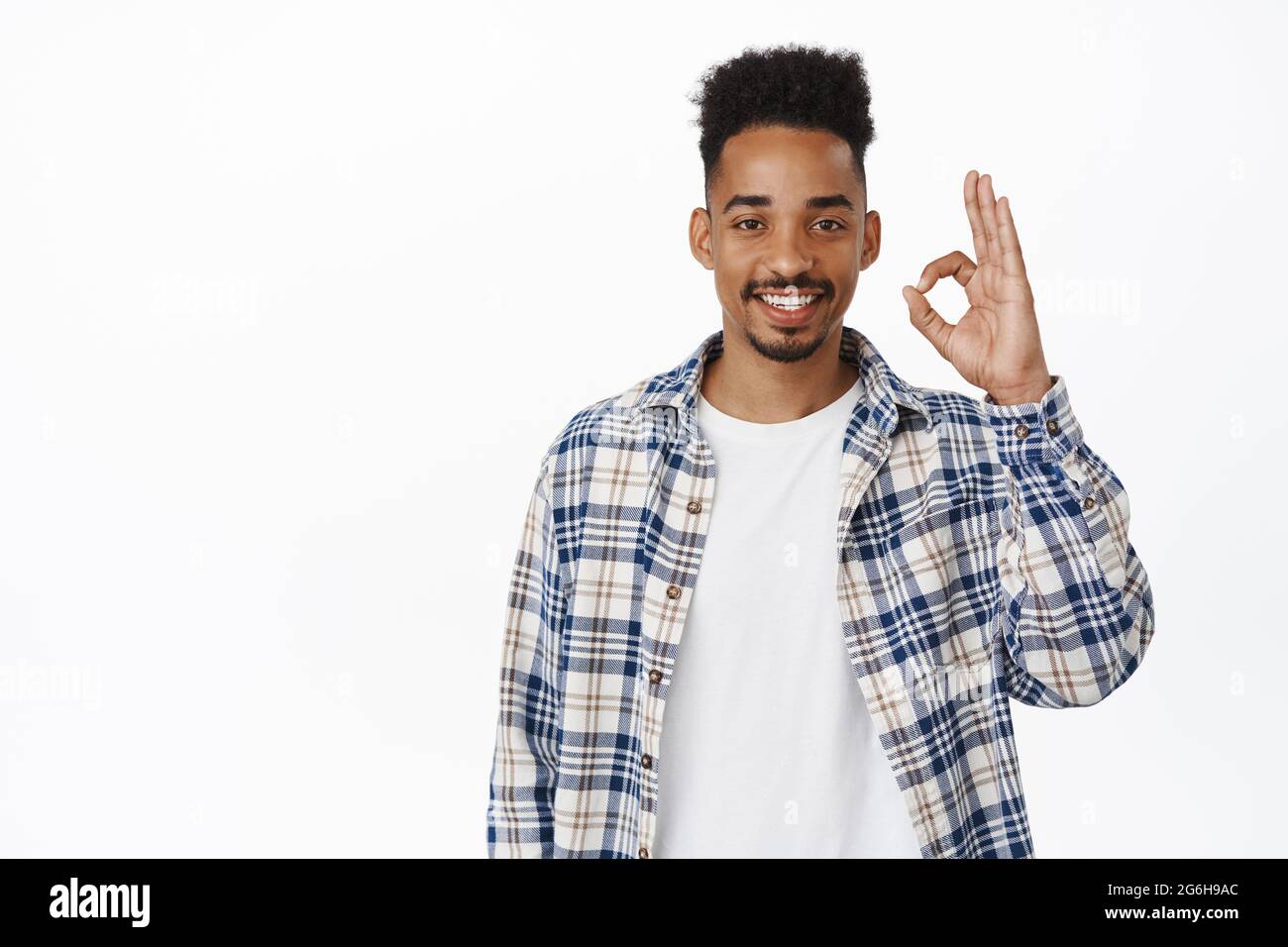 Okay, very good. Smiling handsome young man, african american guy shows ...