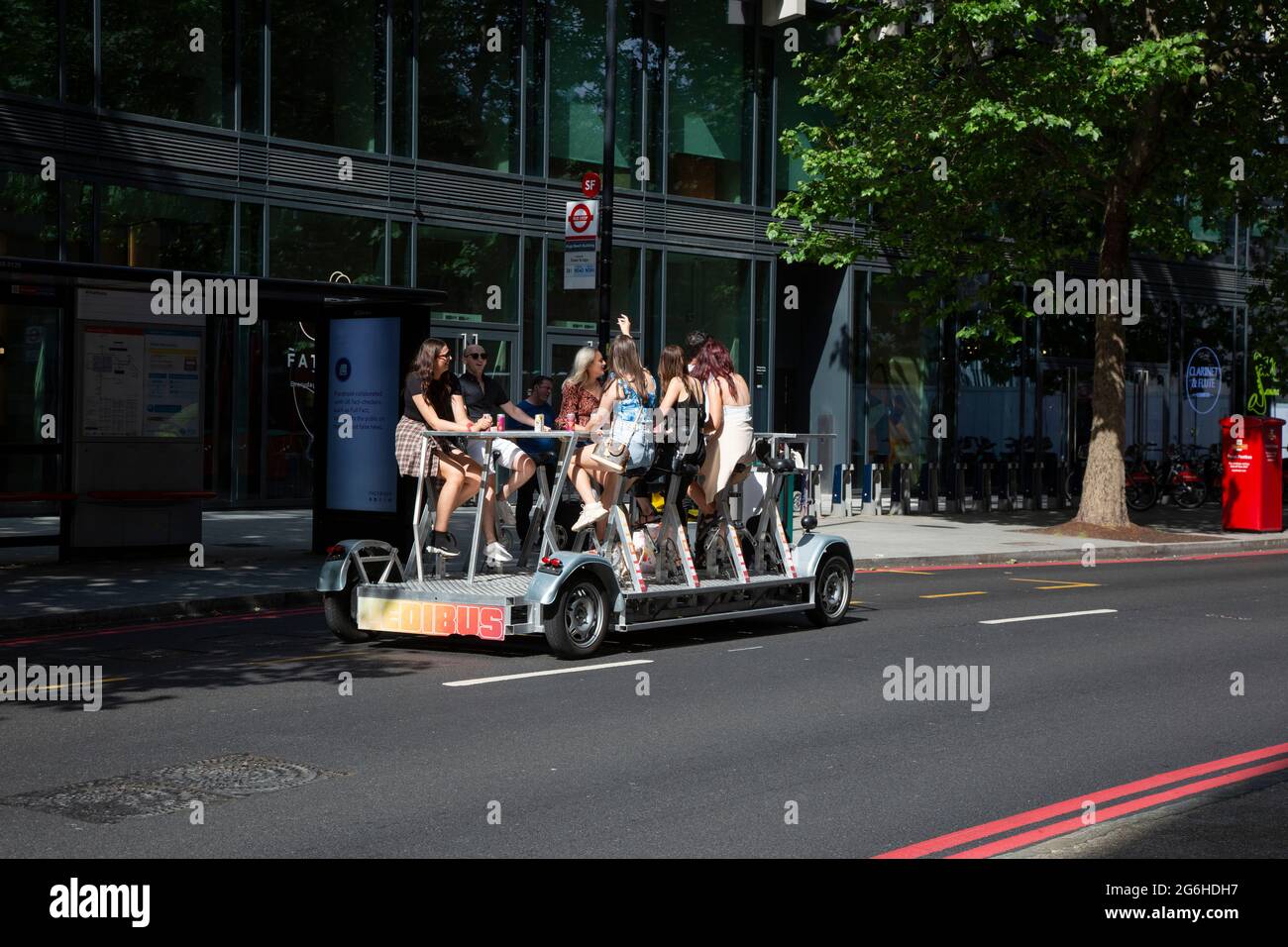 People enjoying the sunshine on a Pedibus, also called a beer bike in Central London. Stock Photo