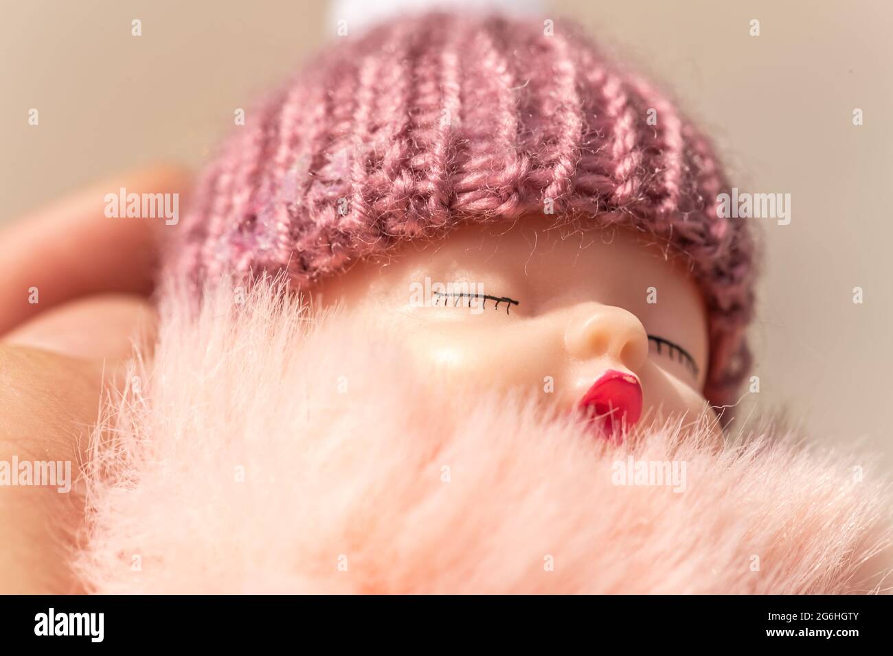 Close-up of a sleeping baby puppet held by a person Stock Photo