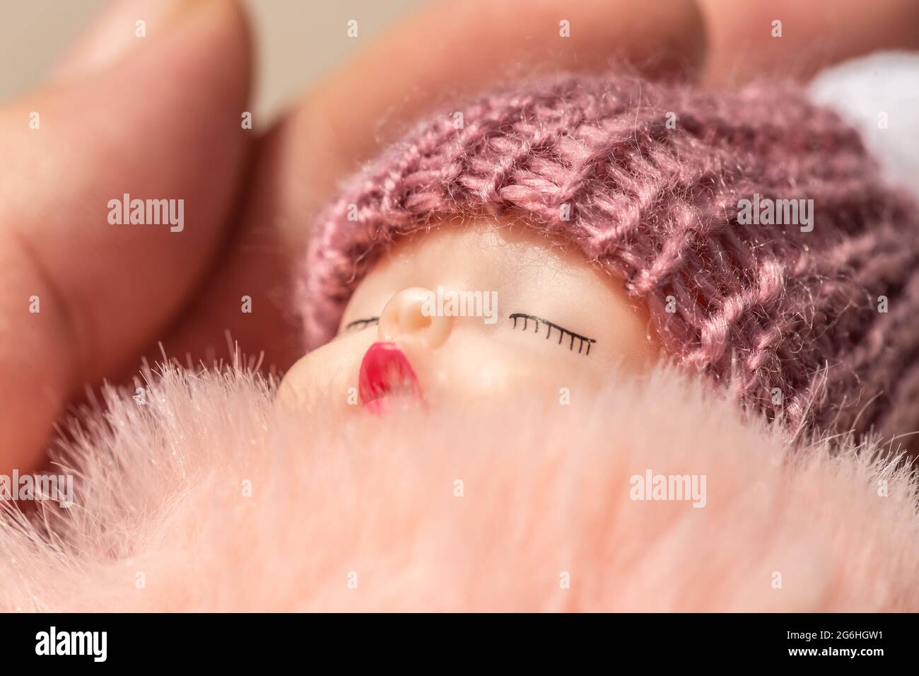 Close-up of a sleeping baby puppet held by a person Stock Photo