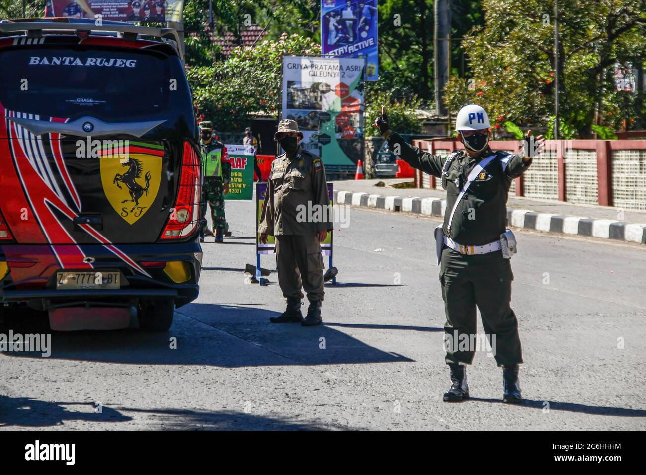 Indonesian police officers give directions as they check travel