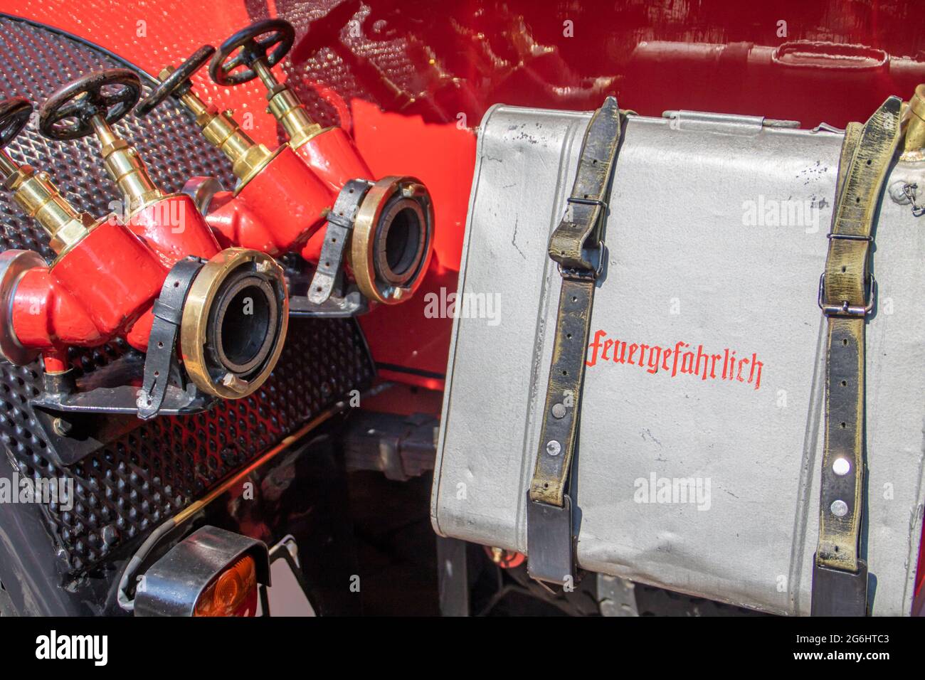 Detail of an old fire truck with connections for hoses end the word feuergefährlich, flammable in German on an attached box Stock Photo