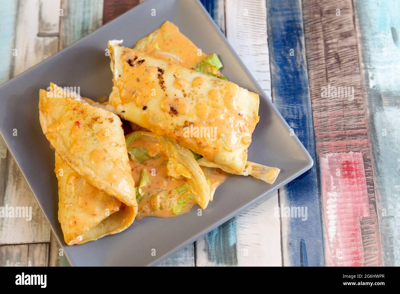 seafood crepe cut in half and covered with sauce Stock Photo
