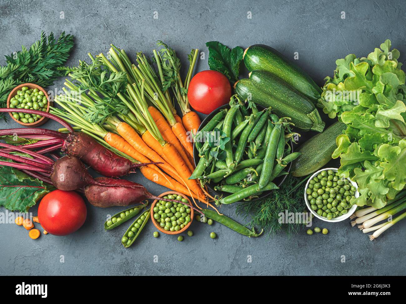 An assortment of fresh vegetables on a gray-blue background. Top view, copy space. Tinted image. Stock Photo