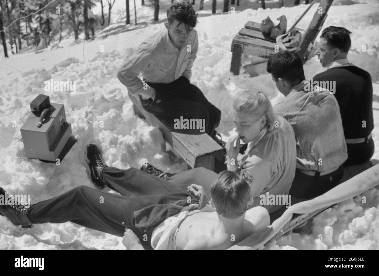 Skiers relaxing in the sun during noon hour outside of forest ranger's hut near the top of Mount Mansfield, Smuggler's Notch, near Stowe, Vermont, circa 1940 Stock Photo