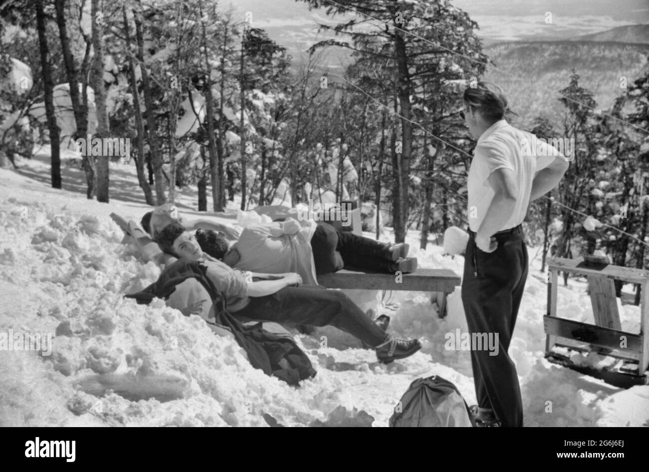 Skiers relaxing in the sun during noon hour outside of forest ranger's hut near the top of Mount Mansfield, Smuggler's Notch, near Stowe, Vermont, circa 1940 Stock Photo