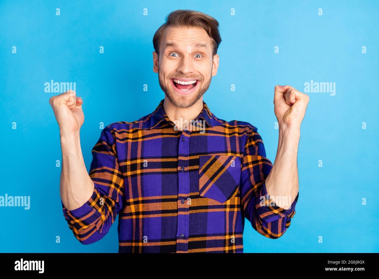 Photo of delighted positive man fists up open mouth celebrate look ...