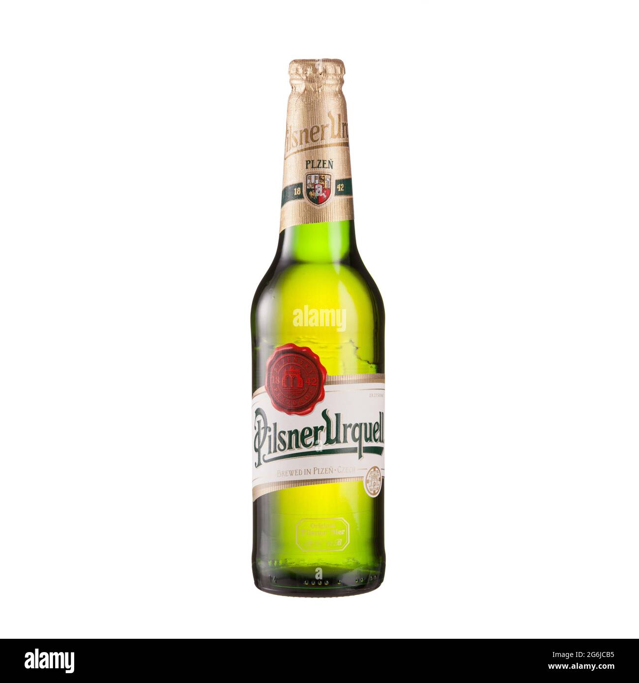 Pilsner Urquell beer bottle on glass table isolated against white background - Volgograd, Russia - June 03, 2021. Stock Photo