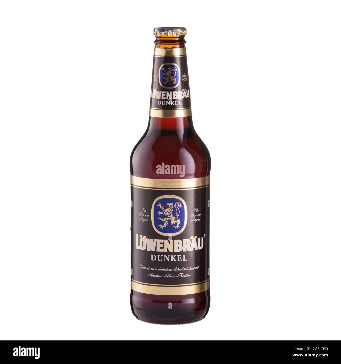 Lowenbrau Dunkel. Dark beer bottle on glass table isolated against white background - Volgograd, Russia - June 03, 2021. Stock Photo