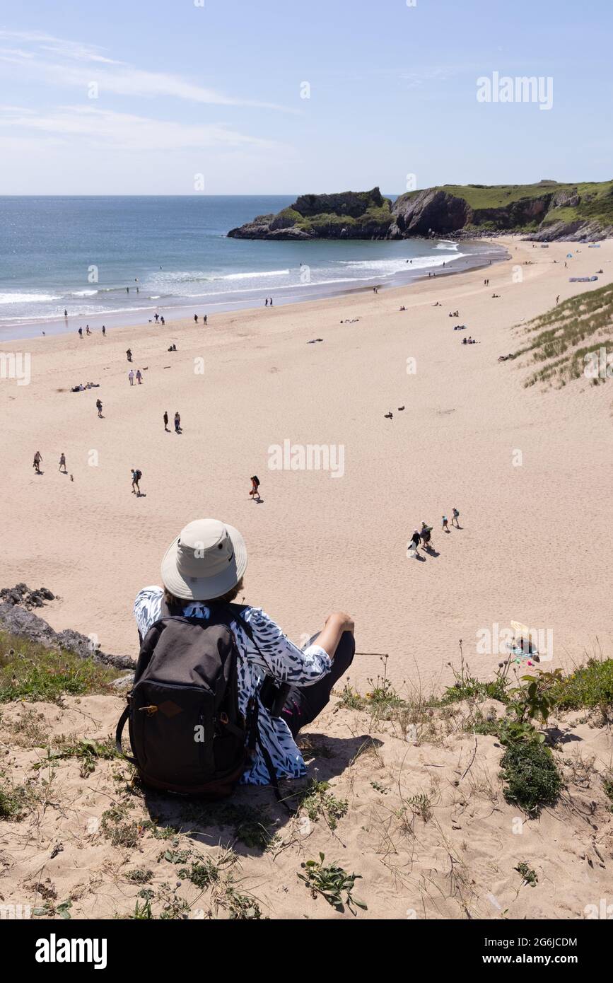 Staycation UK; a woman looking over Broad Haven beach in summer sunshine, Stackpole Estate, Pembrokeshire Coast, Pembrokeshire Wales UK Stock Photo
