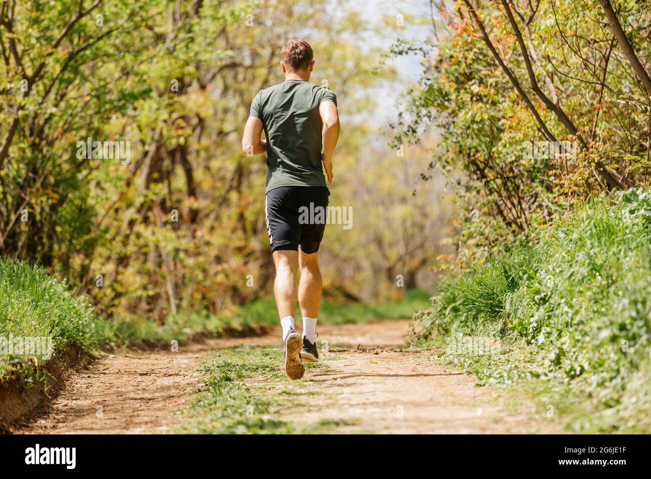 Sport man running. Portrait of runner man jogging in park. Sport