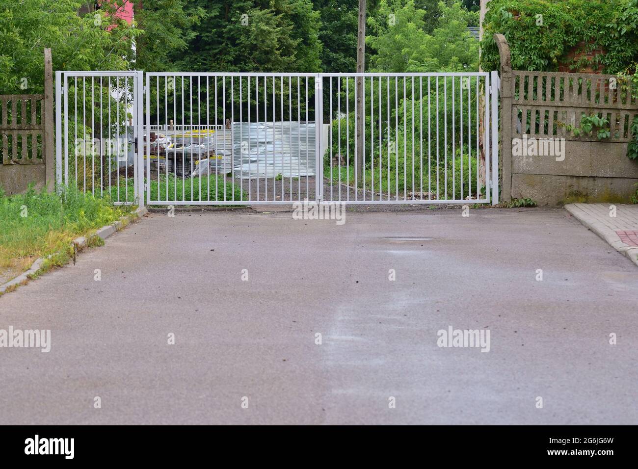 Metal gate at the end of the asphalt road. Stock Photo