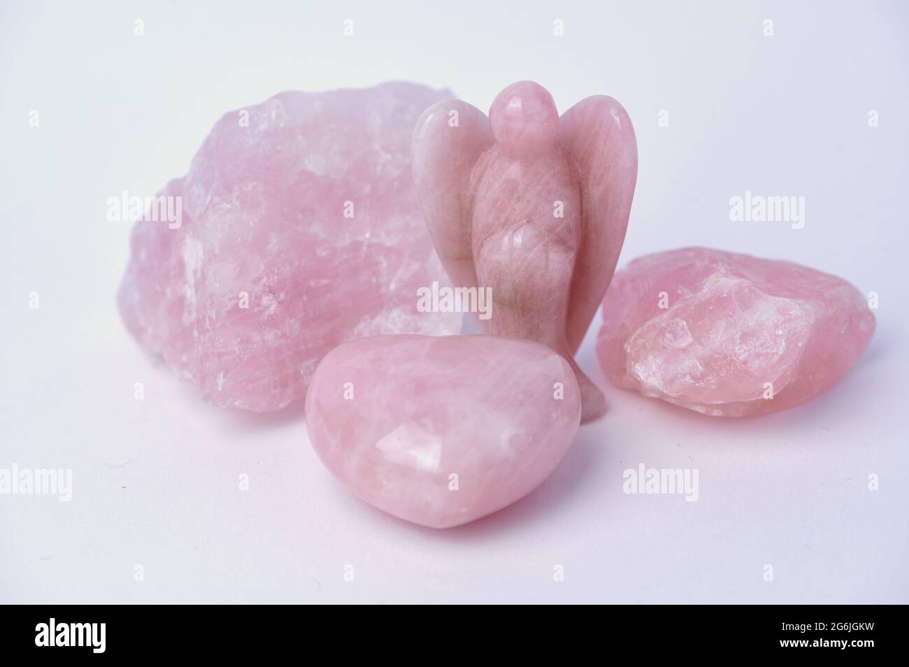 Rose quartz gemstone in different shapes, rough stone, angel or also heart on white background Stock Photo
