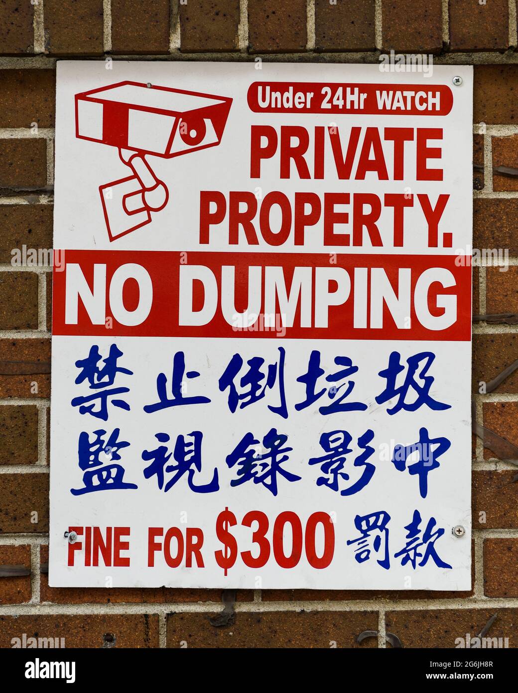 Red and blue sign in Chinatown for Private Property and No Dumping, written in English and Chinese with a fine for $300 Stock Photo