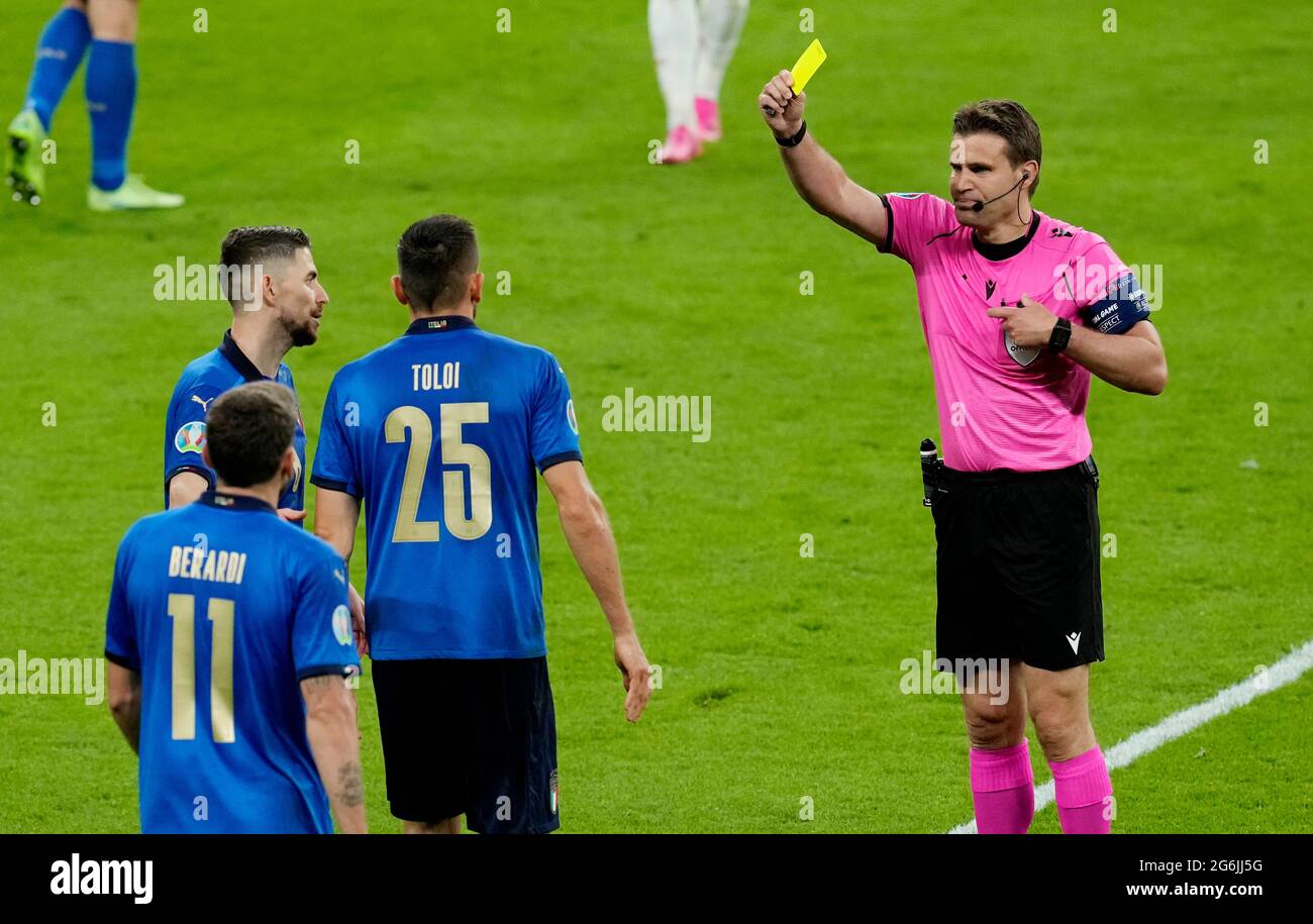 Soccer Football - Euro 2020 - Semi Final - Italy v Spain - Wembley Stadium, London, Britain - July 6, 2021 Italy's Rafael Toloi is shown a yellow card by referee Felix Brych Pool via REUTERS/Matt Dunham Stock Photo