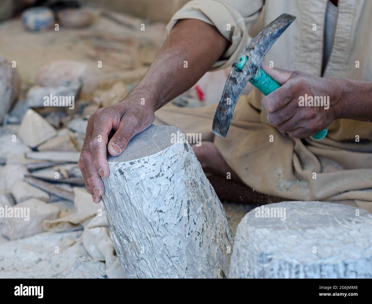hands of a male Egyptian sculptor while working with a stone alabaster