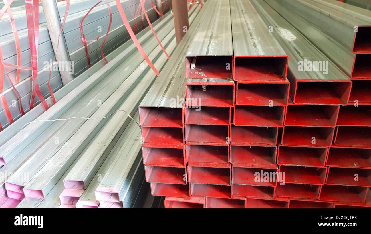square metal pipe Carbon Steel Pipe Section Stainless steel bars are stacked on top of each other in a metal product warehouse. Stock Photo