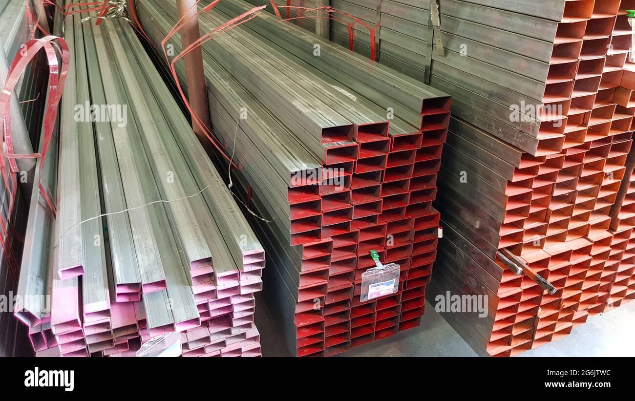 square metal pipe Carbon Steel Pipe Section Stainless steel bars are stacked on top of each other in a metal product warehouse. Stock Photo