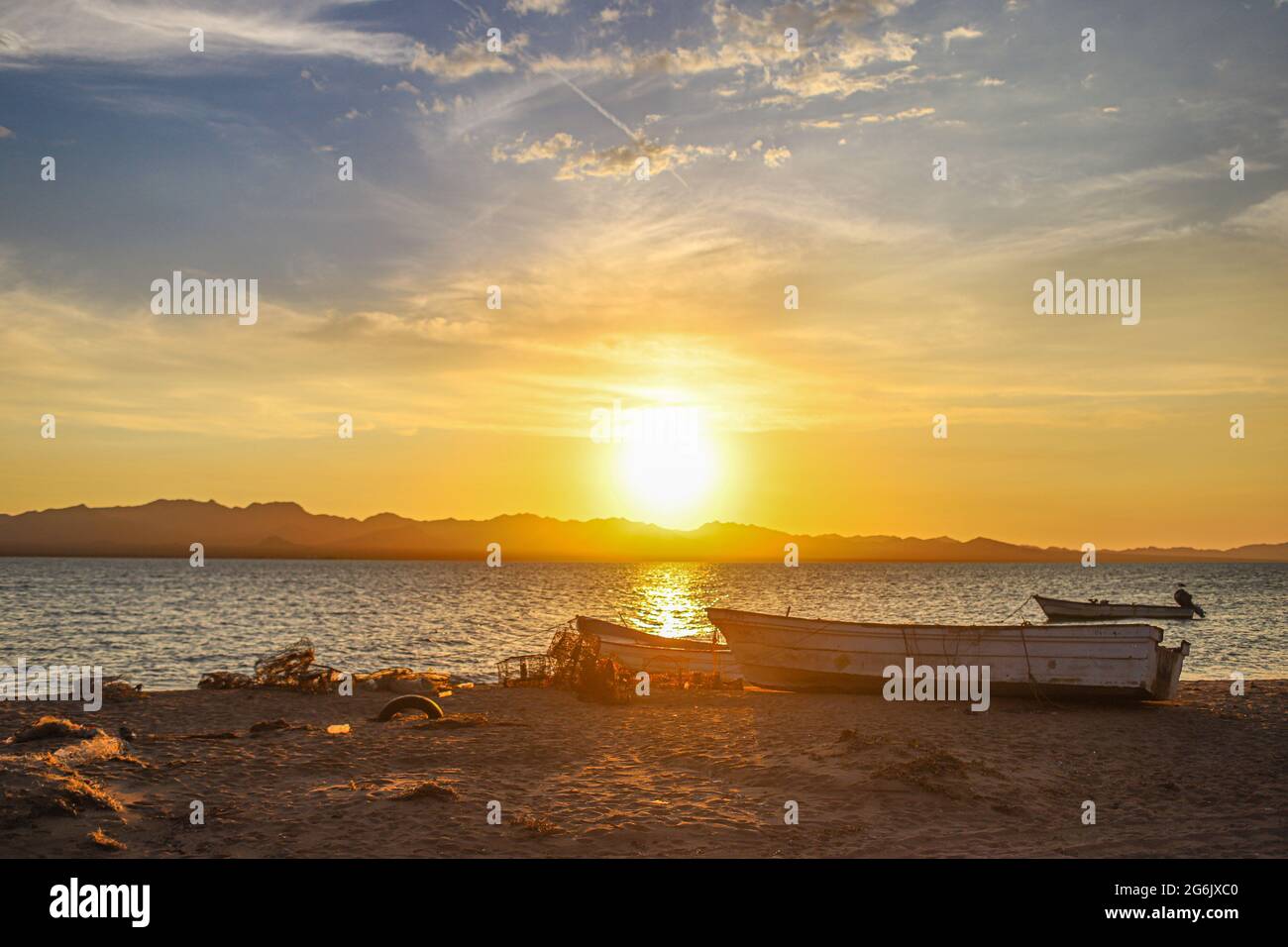 Un Bote de pesca flota en el agua atardecer en la playa de frente  Isla del Tiburon en la localidad de Punta Chueca durante la celebración año nuevo Seri en la comunidad de Punta Chueca el 30 junio 2021 en Hermosillo, Mexico.(Foto by Luis Gutierrez / Norte Photo )  A fishing boat floats in the sunset water on the beach in front of Isla del Tiburon in the town of Punta Chueca during the Seri New Year celebration in the community of Punta Chueca on June 30, 2021 in Hermosillo, Mexico. (Photo by Luis Gutierrez / North Photo) Stock Photo