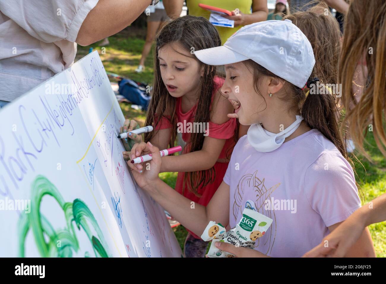 NEW YORK, NY – JULY 05: Children sign a poster calling to save the park during a rally in Rockefeller Park to protest Gov. Andrew Cuomo's plans for a Stock Photo