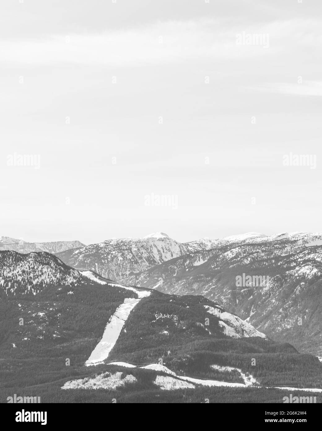 black and white snow-capped Columbia Mountains against the blue sky in British Columbia Canada. Stock Photo