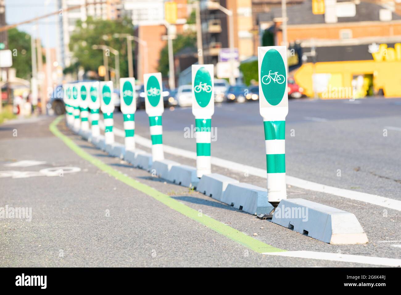 Safety barriers for bicycle lanes on the street, selective focus on the front green post with soft focus background. Stock Photo