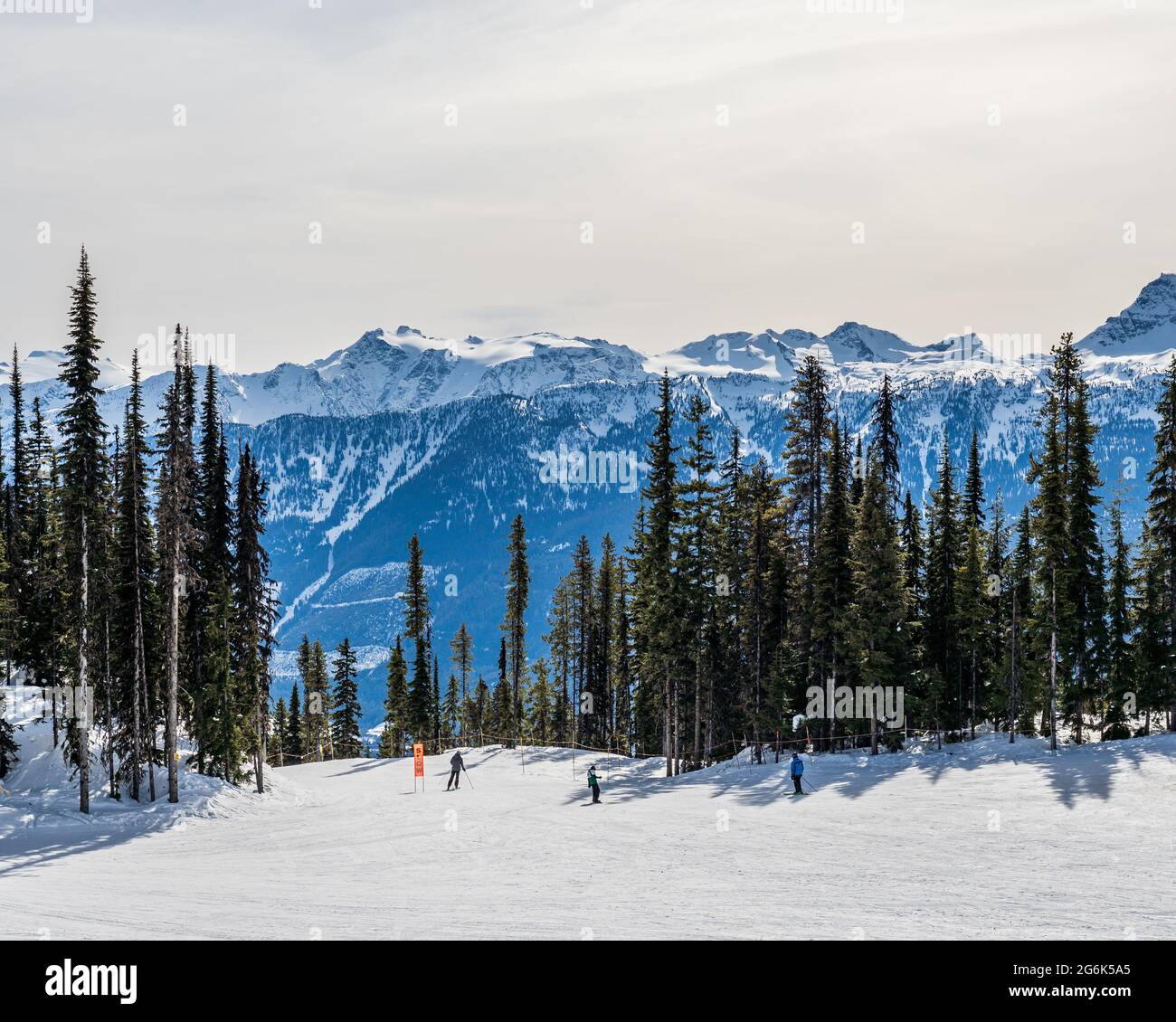 REVELSTOKE, CANADA - MARCH 17, 2021: Skiers and snowboarders going down the slope in canadian mountains Stock Photo