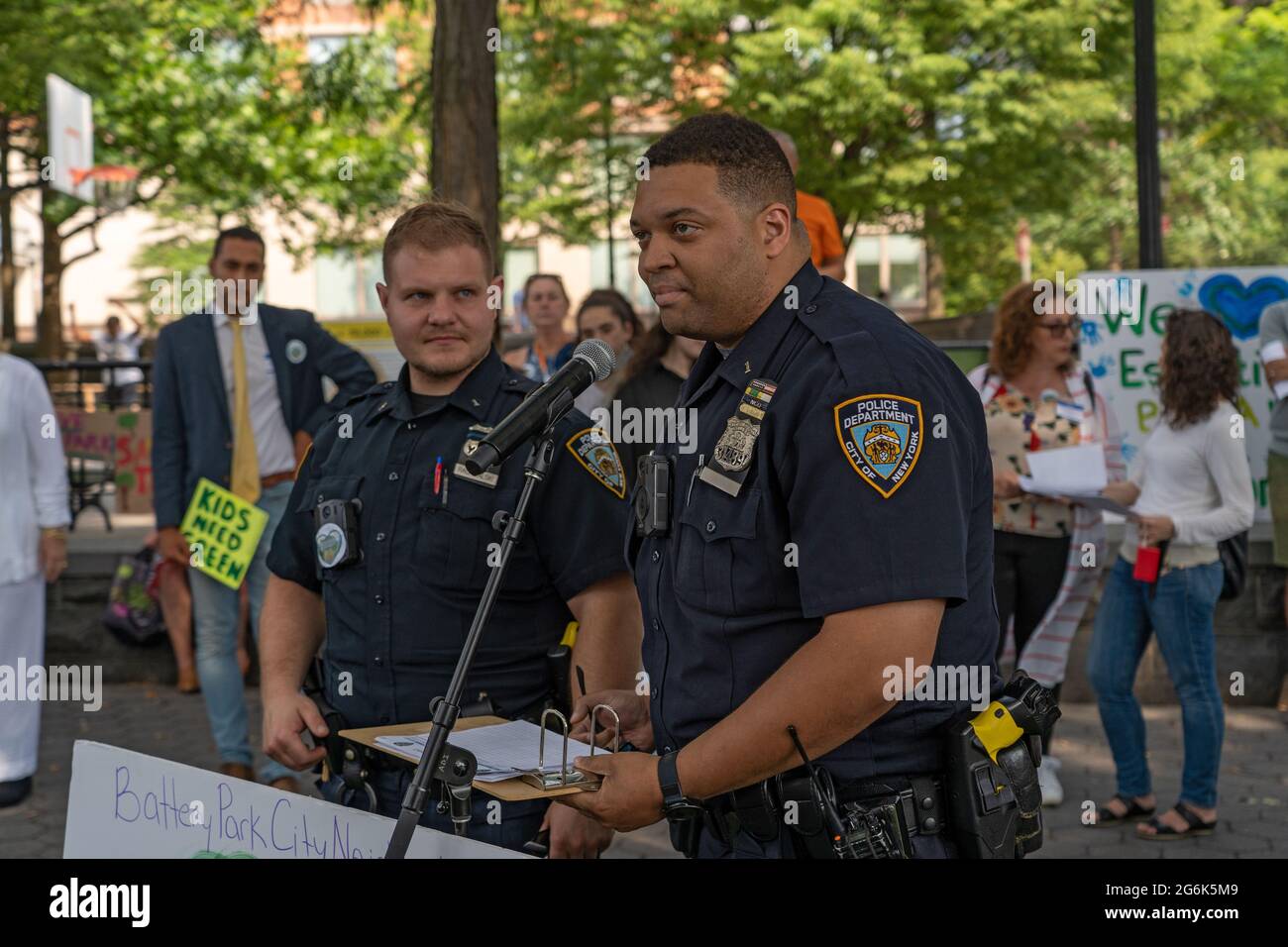 New York Police Department (NYPD) Officers Michael Rachwalski (L) and Miles Holman (R) from the 1ST Precinct speak during a protest against Governor Andrew Cuomo's plans for a COVID-19 memorial in New York City.Two hundred protestors rallied in lower Manhattan's Rockefeller Park as they sought to keep up the pressure on Governor Andrew Cuomo just days after the powerful and scandal-scarred state leader nixed his plans to pave over a portion of the green space for the, coronavirus memorial, 'circle of heroes' monument. The Battery Park City protest occurred as Community Board 1, which represe Stock Photo