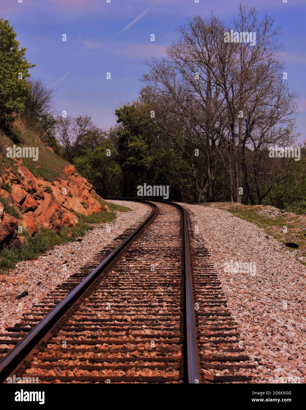 Single train tracks going around a curve of rocks in North Carolina