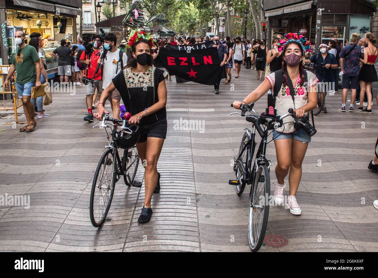 Barcelona, Spain. 06th July, 2021. Women seen with bicycles, during the event.Barcelona welcomes the 421 Squadron of the Zapatista Army of National Liberation (EZLN), a libertarian socialist political and militant group of Mexico, on their way through Europe. Composed of different members. The 421 Squad has been received at the Columbus Monument by local collectives and social organizations. Credit: SOPA Images Limited/Alamy Live News Stock Photo