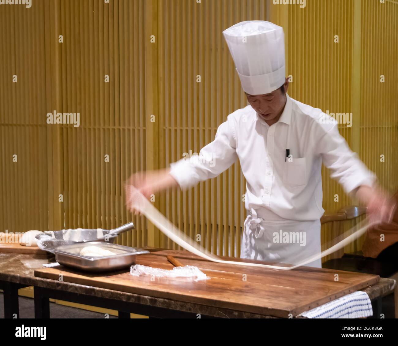 A chef makes biang biang noodles, also known as 'belt' noodles because of their thickness and length, in Xi'an, Shaanxi Province, China. Stock Photo