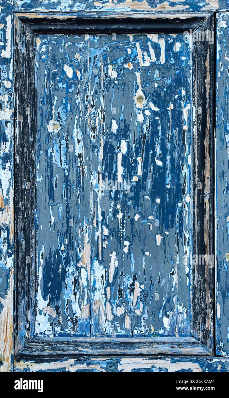 A blue door panel with very worn paint showing the wood underneath Stock Photo