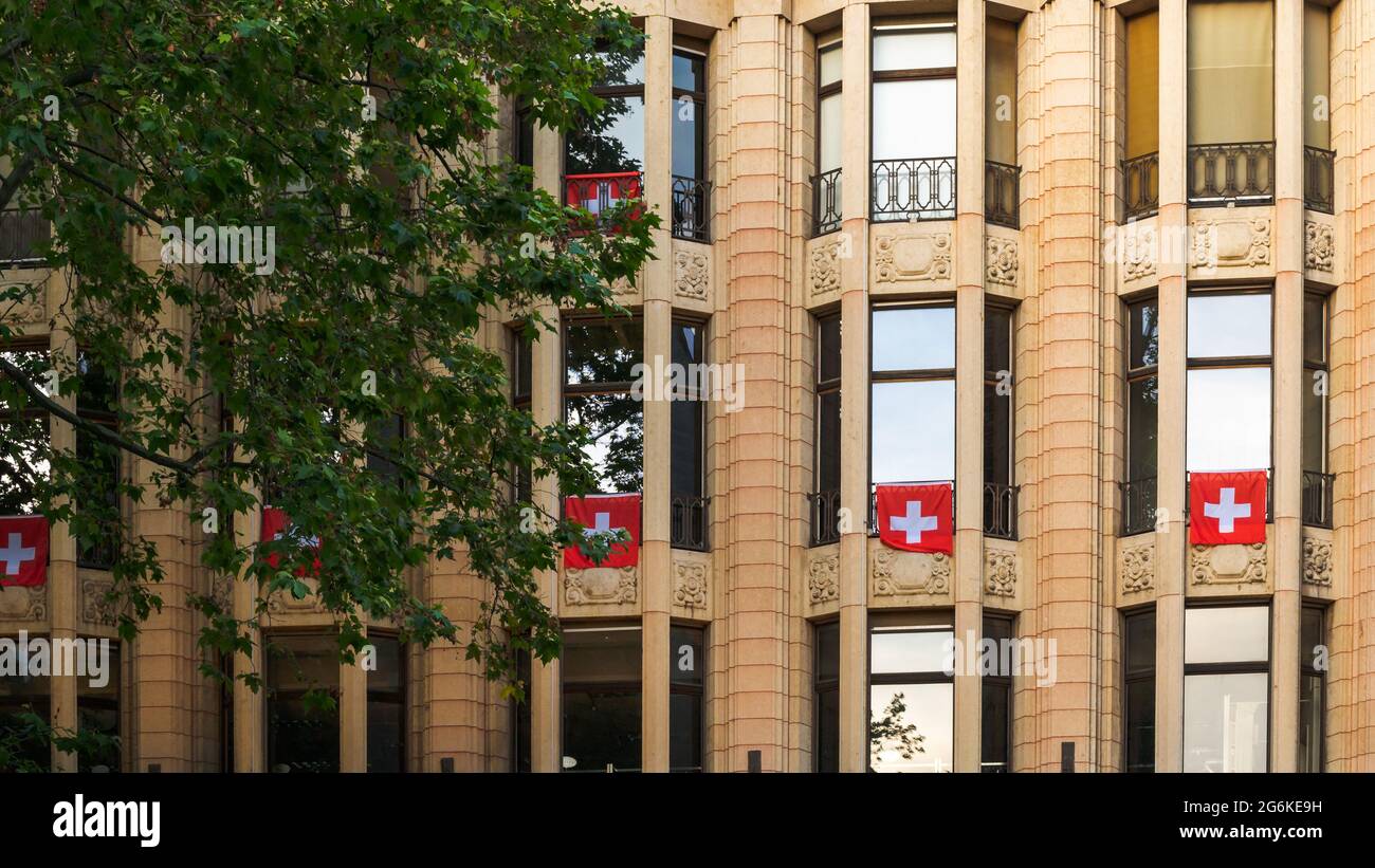 Flags of Switzerland hang on from balcony in Lausanne, Switzerland. Swiss flags. Stock Photo