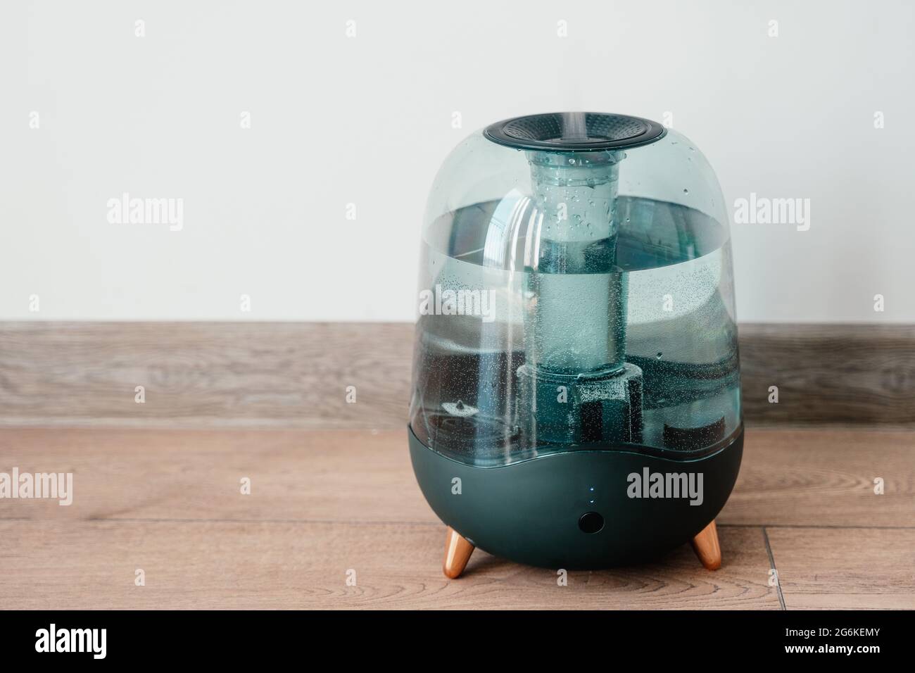 Modern air humidifier on a white wall background. Humidifier spreading steam into the living room Stock Photo