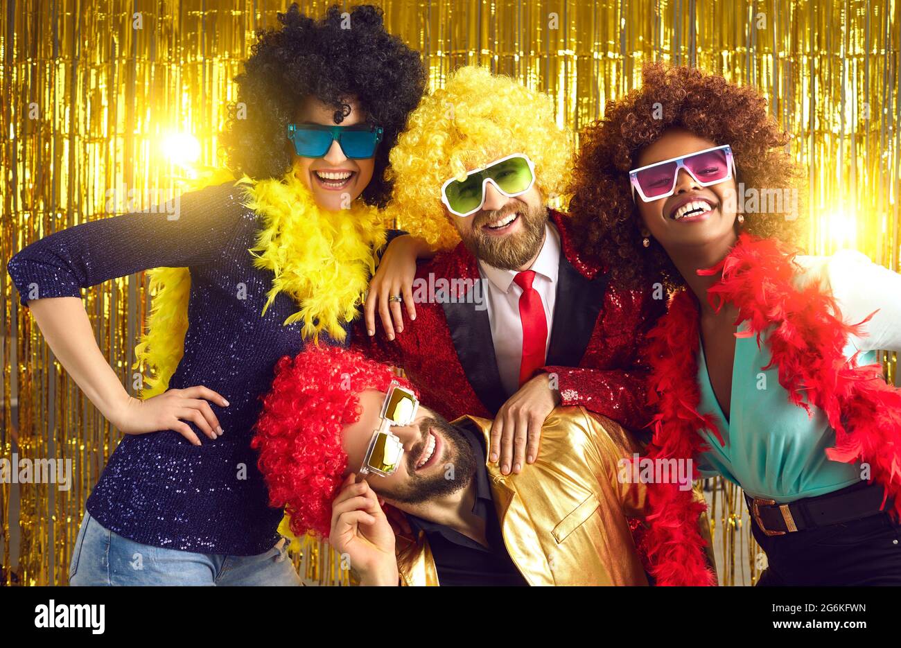Toothy smiling positive carefree friends posing for camera in party hair wig Stock Photo