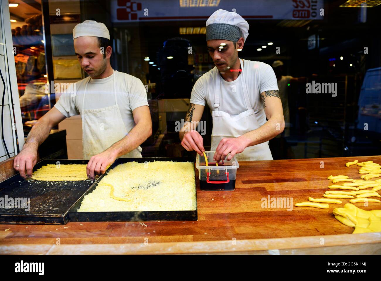 Pastry chefs working on a cheese covered Greek pastry Stock Photo Alamy