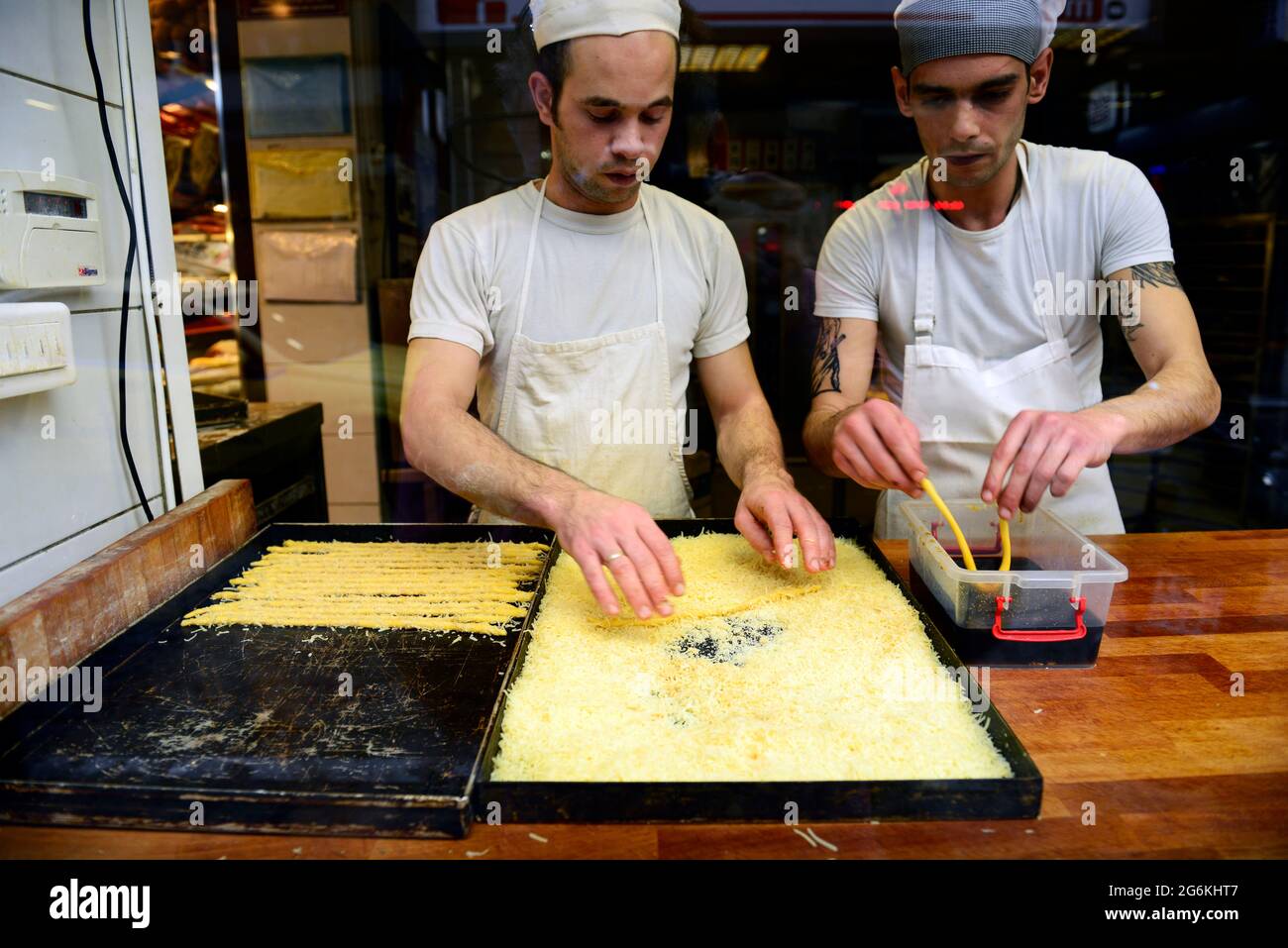 Pastry chefs working on a cheese covered Greek pastry Stock Photo Alamy