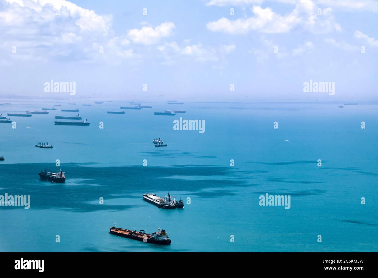 Aerial view of container ships in Singapore Strait. Airplane shot. Cargo ships anchored in the road, waiting to enter the busiest port in region.  Stock Photo