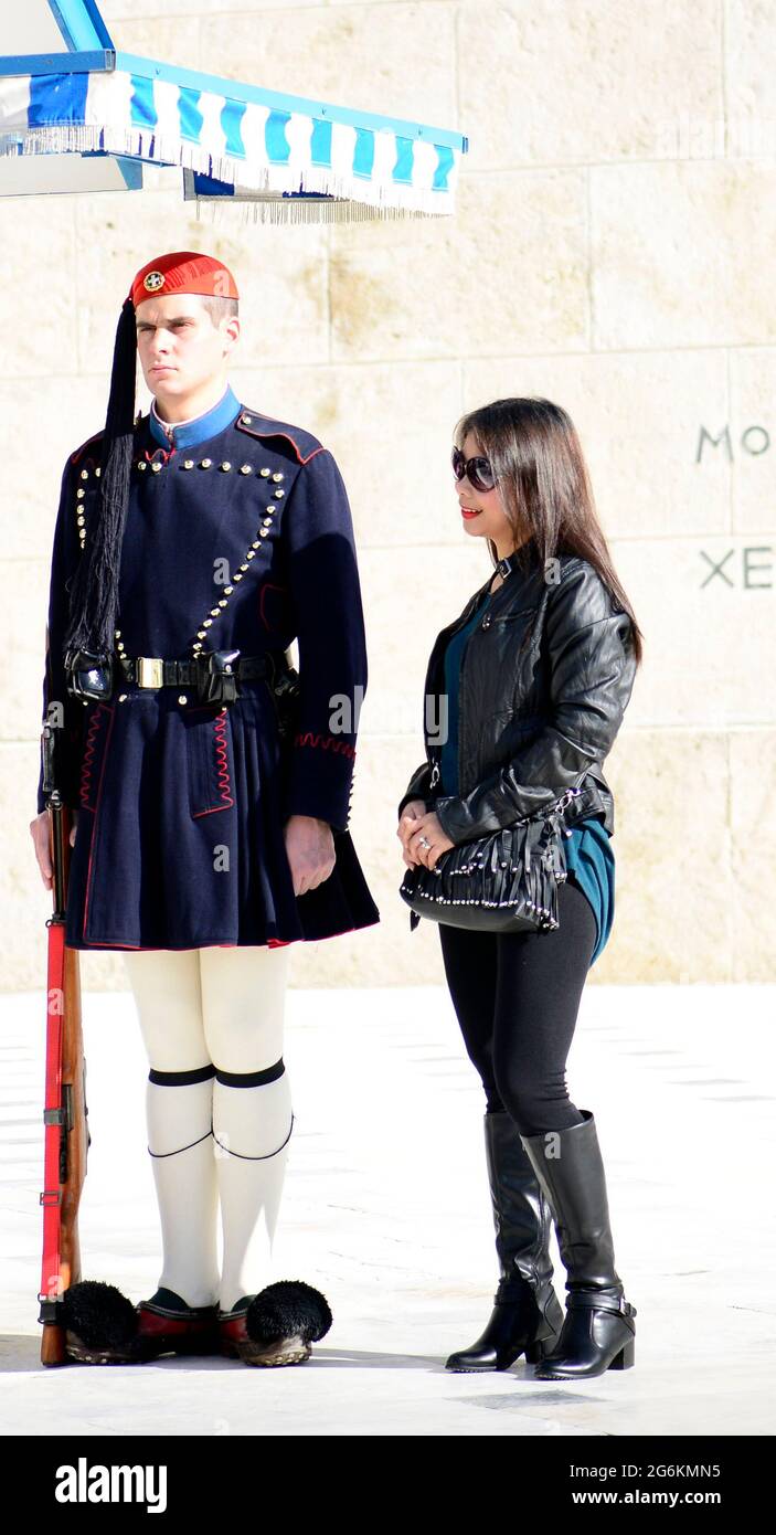 An Asian tourist posing for a photo by a Greek national guard soldier by the tomb of the unknown soldier at the Greek parliament building in Athens. Stock Photo