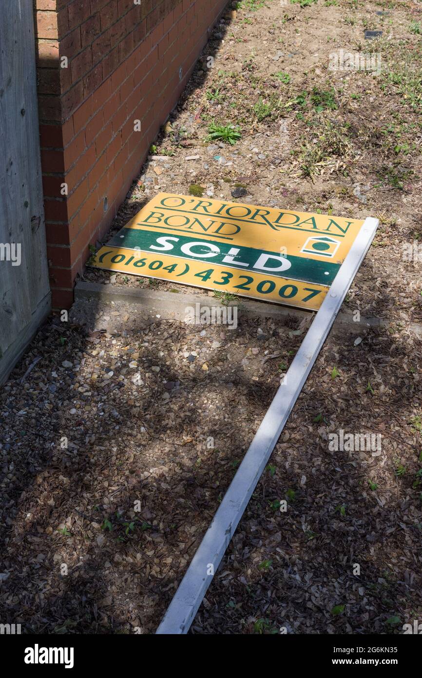 Estate Agent sold sign uprooted and laying on the ground, Northampton, UK; concept for falling house sales and house prices Stock Photo
