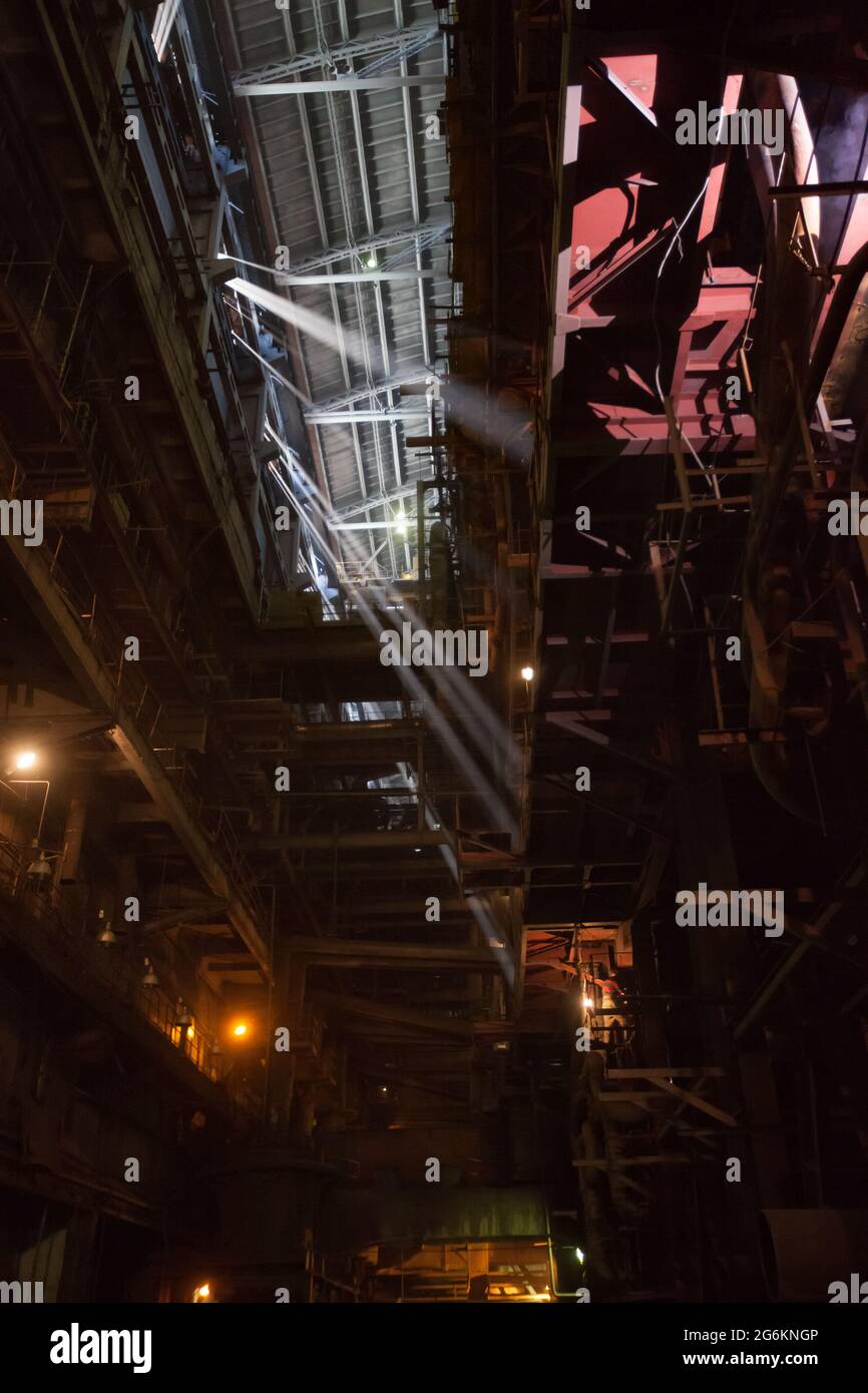 Aksu, Kazakhstan - May 29, 2012: Interior of electric power plant with boiler. Sun rays in steamed air. Dark background. Profile roof. Stock Photo